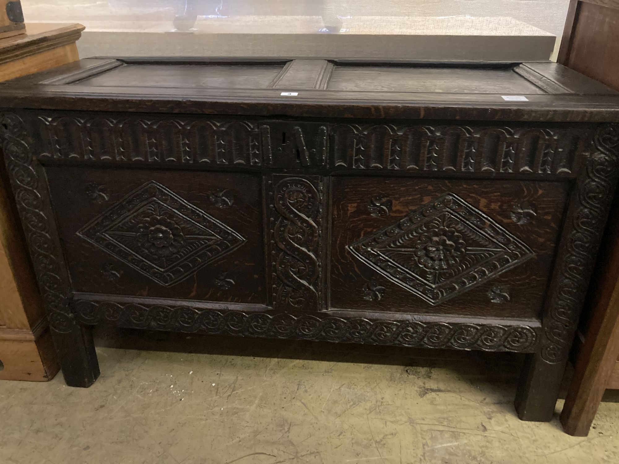 An 18th century carved oak coffer with twin panelled front, width 125cm, depth 55cm, height 75cm